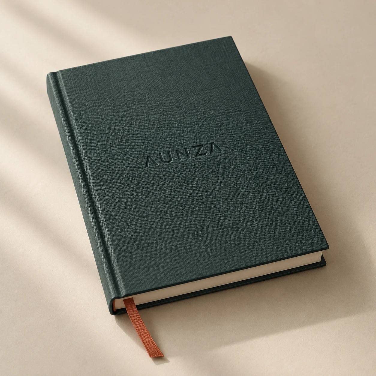 Cuaderno de lino verde oscuro con el logotipo de AUNZA en relieve