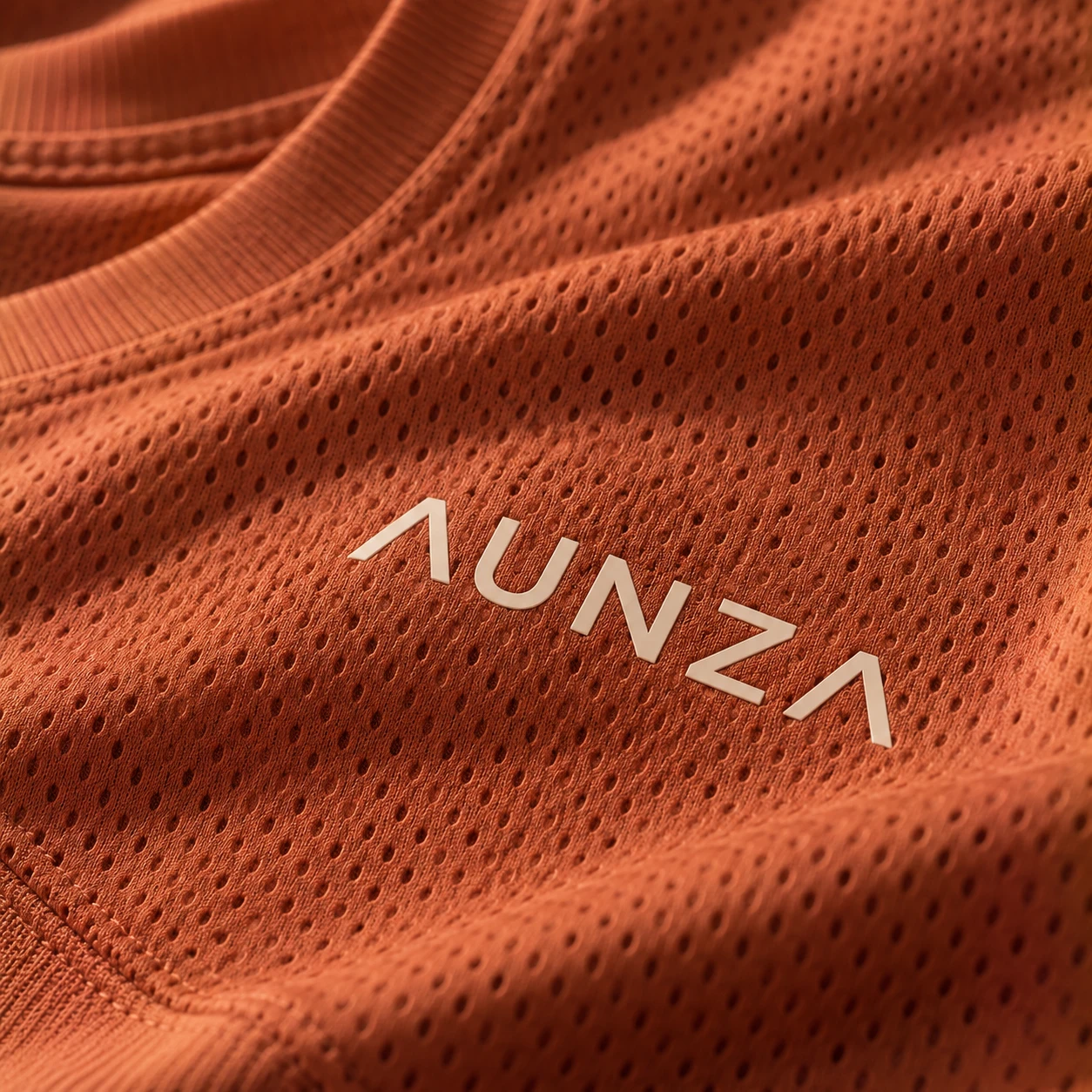 Logotipo en transfer térmico sobre una camiseta deportiva de color terracota
